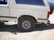 1988 Ford Bronco - Rear view of a white Ford Bronco, showing the spare tire and side panel.