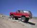 1988 Ford Bronco - A red 1978 Dodge Ramcharger is shown off-roading on a sunny day.