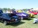 1978 Ford Mustang II - Several classic cars are parked on a grassy field under a clear blue sky at an outdoor event.