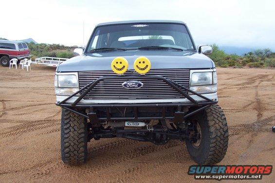 Gray Ford Bronco front view with off-road bumper and yellow smiley face lights
