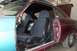 1966 Ford Fairlane - The interior of a classic car shows dark seats and a partially painted door, with a bucket inside.