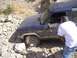 1989 Ford Bronco - A dark blue 1989 Ford Bronco II navigates difficult rocky terrain, with a person attending to the vehicle.