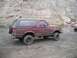 1989 Ford Bronco - Muddy 1989 Ford Bronco parked off-road; other vehicles visible in the distance.