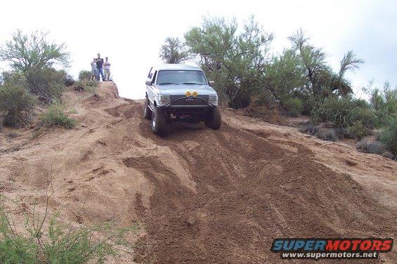 Silver 1992 Ford Bronco climbing a dirt hill