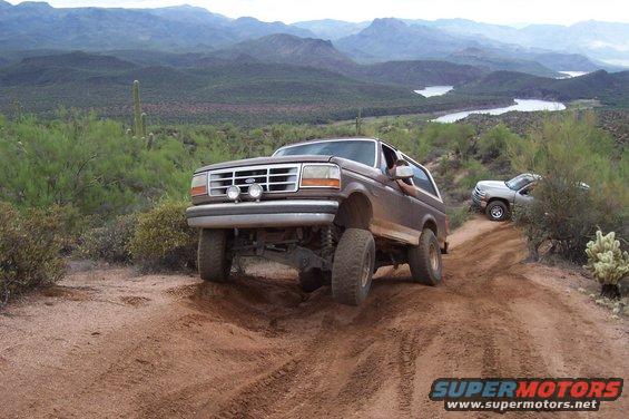 Brown 1992 Ford Bronco on a dirt trail with another vehicle behind it