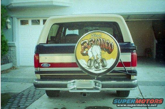 Rear view of a 1991 Ford Bronco with a spare tire cover a cartoon horse. Ford logo visible on tailgate