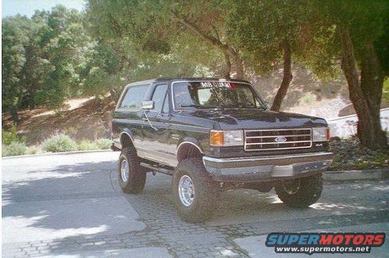 Black Ford Bronco with lifted suspension and off-road tires parked on a paved surface