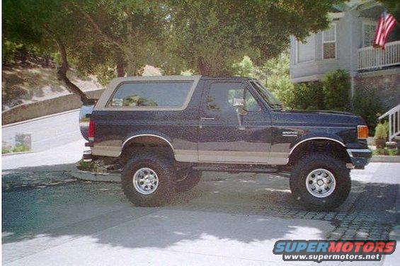 Side view of a dark blue and tan 1991 Ford Bronco with lifted suspension