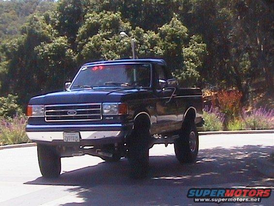 Dark blue Ford F-150 pickup truck, front 3/4 view. License plate visible