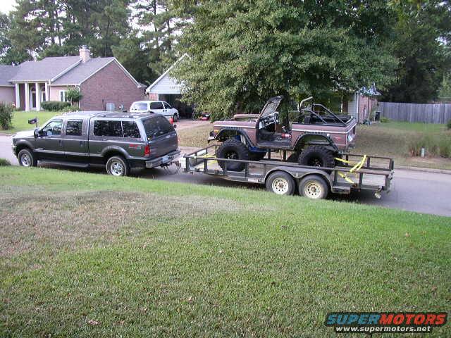 Ford Bronco on a trailer being towed by an SUV