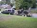 1995 Ford Bronco - A brown Ford Bronco is loaded onto a trailer, which is being towed by a dark gray SUV.