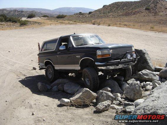 Black Ford Bronco with lifted suspension navigating a rocky trail