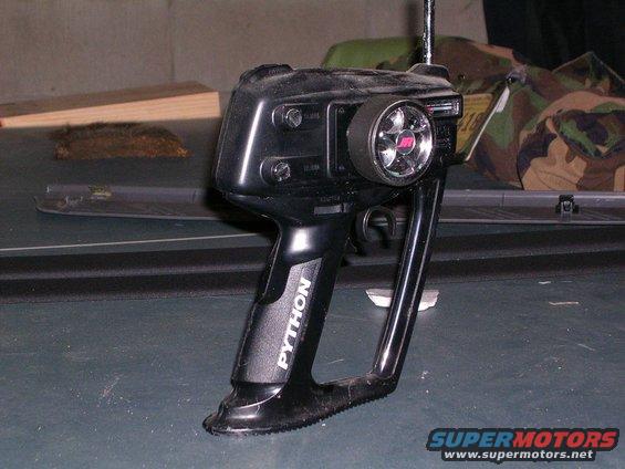 Black remote control transmitter with a steering wheel and trigger grip. Text on the handle says 'PYTHON'