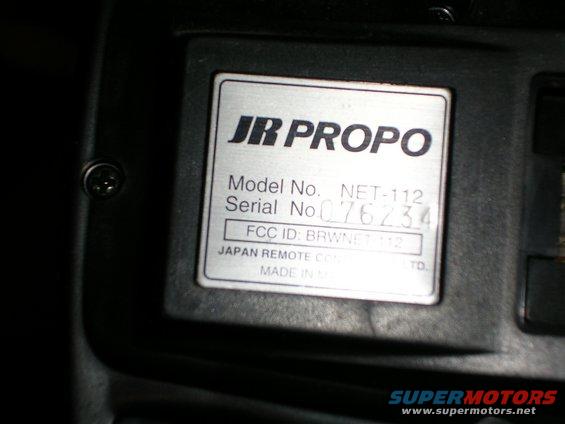 Silver label with black text on a black device, showing JR PROPO Model No. NET-112, Serial No. 076234, FCC ID: BRWNET112, and JAPAN REMOTE CO., LTD. MADE IN JAPAN