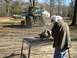 1995 Ford Bronco - A person works on a metal component outdoors with a tractor visible in the background.