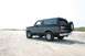1993 Ford Bronco - A Ford Bronco is parked on a sandy beach with dunes in the background.