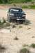 1993 Ford Bronco - Black 1993 Ford Bronco navigates rocky terrain on a dirt road.