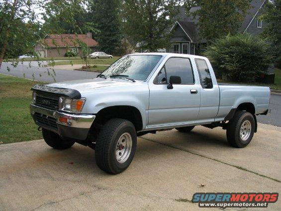 Silver pickup truck, 3q front view. Supermotors.net logo visible