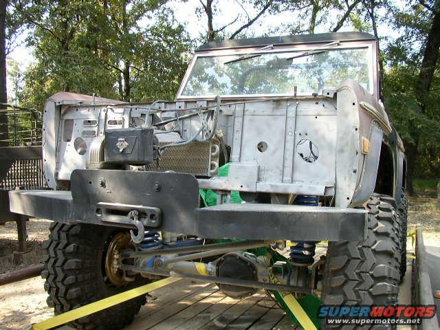 Unfinished Ford Bronco front end with exposed engine bay, large tires, and a winch