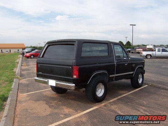 Black 1986 Ford Bronco parked in a lot, rear view