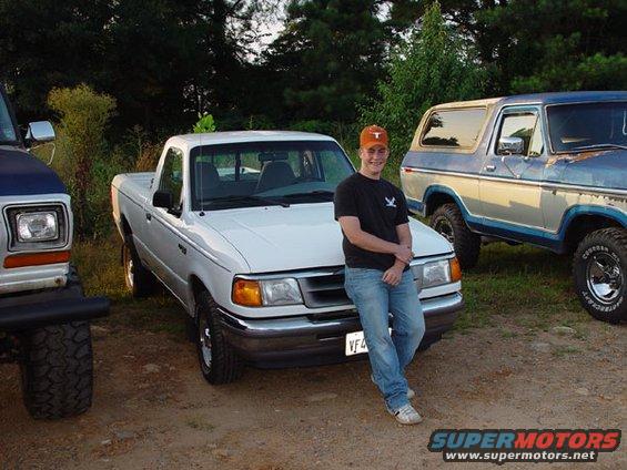 White 1997 Ford Ranger pickup truck parked next to a blue Ford Bronco