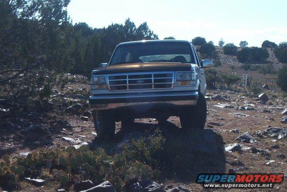 Brown and silver Ford Bronco on rocky terrain, front view
