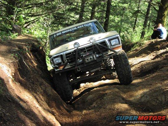 Tan 1979 Ford Bronco off-roading with a winch and brush guard