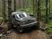 1993 Ford Bronco - This Ford Bronco is navigating a narrow, rocky path through a dense forest.