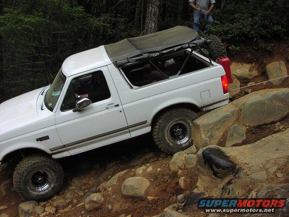White SUV navigating rocky terrain with a soft top removed