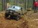 1993 Ford Bronco - A green Ford Bronco navigates a challenging off-road course with another vehicle in the background.