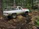 1993 Ford Bronco - This SUV is tackling a challenging off-road course in a wooded area.