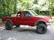 2000 Ford Ranger - This red 2000 Ford Ranger pickup truck is shown from the side, a lifted suspension and large off-road tires.
