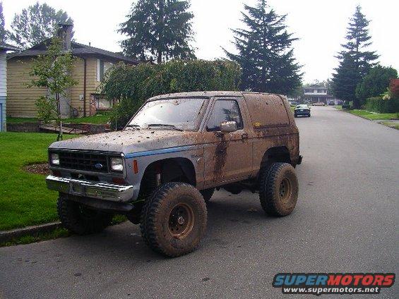 Muddy 1984 Ford Bronco II parked on a residential street