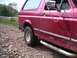 1994 Ford Bronco - Red Ford Bronco on a gravel road, showing its side profile and off-road tires.
