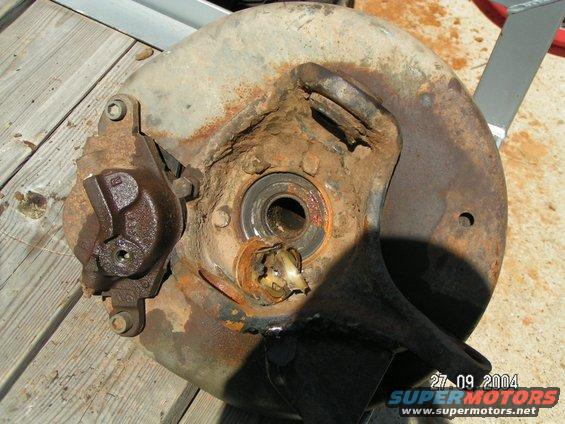 rusted brake caliper and rotor assembly with visible bearing