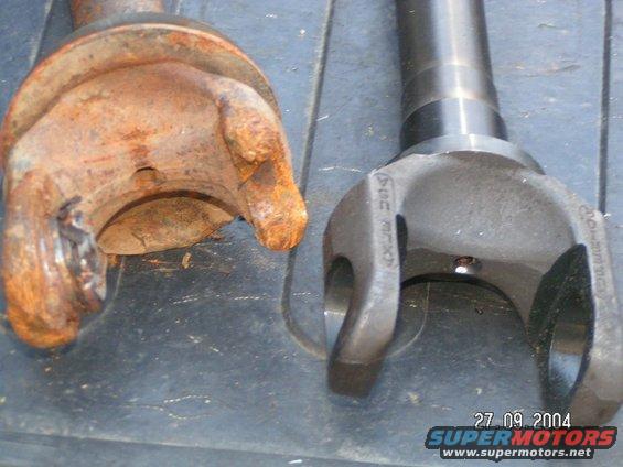 old rusty driveshaft U-joint next to a new one