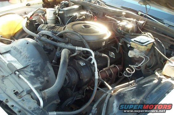 Engine bay with "CAUTION FAN" text on fan shroud