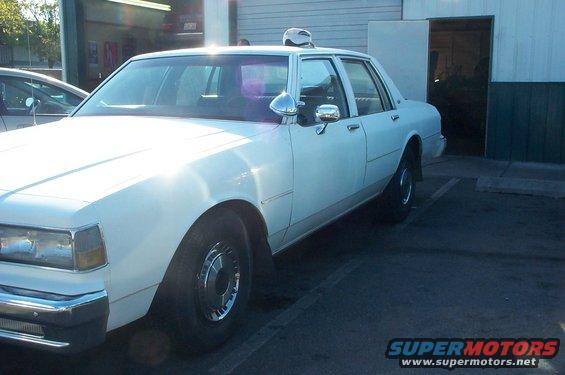 White sedan with chrome trim and a light-colored roof, parked outdoors