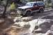 1982 Ford Bronco - A Ford Bronco is shown driving over large rocks on a trail.