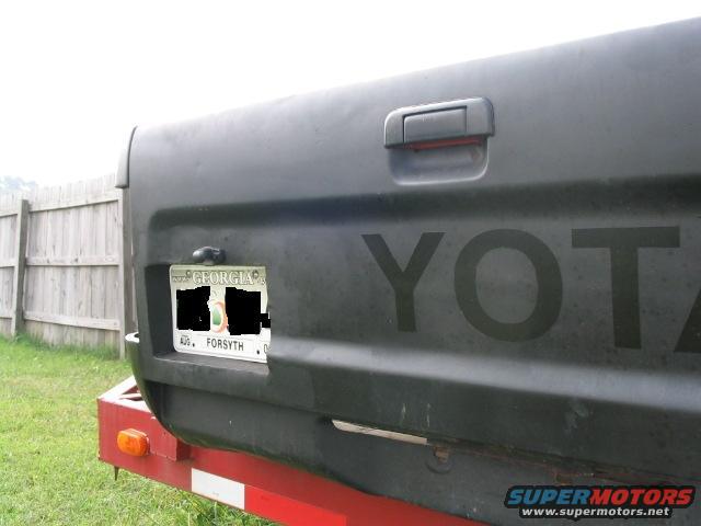 Tailgate of a dark-colored Toyota truck with a Georgia license plate