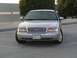 2004 Ford Crown Victoria - A silver 2004 Ford Crown Victoria is shown from the front, displaying its grille and headlights. The vehicle has a Saudi Arabian license pl…
