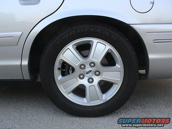 Silver 2004 Ford Crown Victoria rear wheel and fender, close-up side view
