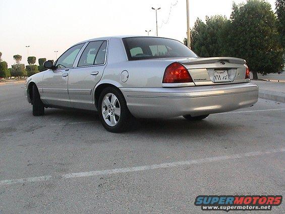 Silver 2004 Ford Crown Victoria parked on asphalt, rear 3/4 view