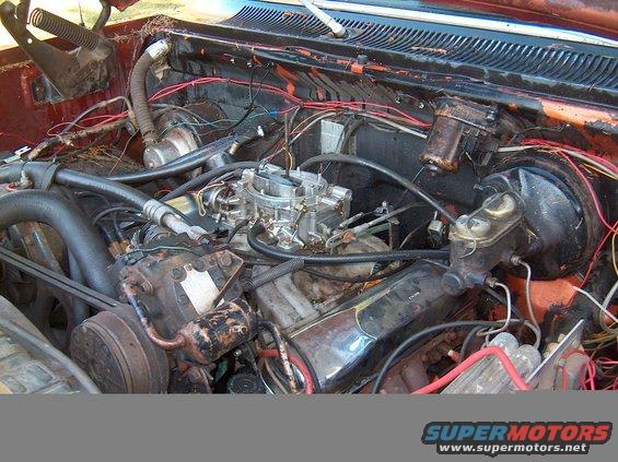 Engine bay with carburetor, brake master cylinder, and various hoses and wires