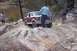 1982 Ford Bronco - A man walks near a Ford Bronco as it drives over rocks.
