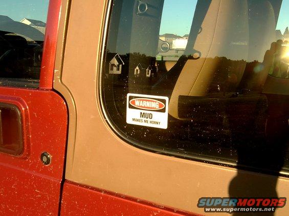 Red Jeep door with "MUD MAKES ME HORNY" sticker