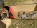 1989 Ford Bronco - Driveshaft U-joint and broken metal pieces are laid out on the grass.