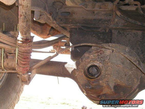 Rear axle and suspension of a vehicle, showing leaf springs and shock absorber
