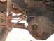 1989 Ford Bronco - Close-up view of the rear axle and suspension system, including leaf springs and a shock absorber.