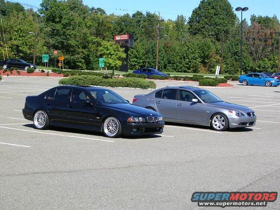 Black BMW 5 Series sedan parked in a lot, 3/4 front view